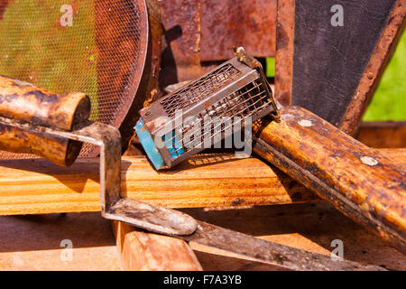 Vintage fumatore e diversi tipi di apicoltore coltelli, filtro di metallo, gabbia per ape regina sulla scatola di legno. Vista ravvicinata di c Foto Stock