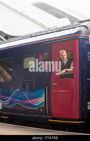 Guardia sul primo treno Great Western alla stazione ferroviaria di Reading a Reading, Berkshire, Regno Unito nel mese di novembre Foto Stock