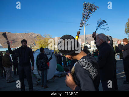 Sciita iraniano Boys coperto di fango sono essi stessi di battitura con catene di ferro per commemorare Ashura, il giorno della morte di imam Hussein, Kurdistan Provincia, Bijar, Iran Foto Stock