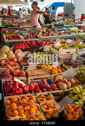 Titolare del mercato si estende mentre per la vendita di frutta nel mercato di Sant'Ambrogio Mercato Sant' Ambrogio Firenze, Italia Foto Stock