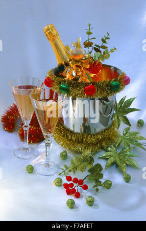 Festive Capodanno Natale ancora in vita con una bottiglia di vino in ghiaccio, due bicchieri e verde palle di Natale su uno sfondo luminoso. Foto Stock