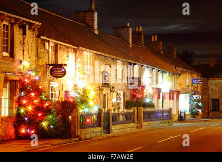 Decorate di alberi di Natale la linea la strada principale di Castleton; un tradizionale villaggio britannico nel Peak District, DERBYSHIRE REGNO UNITO Foto Stock