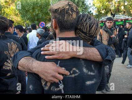 Sciita iraniano uomini musulmani coperto di fango di piangere durante il giorno di Ashura, Kurdistan Provincia, Bijar, Iran Foto Stock