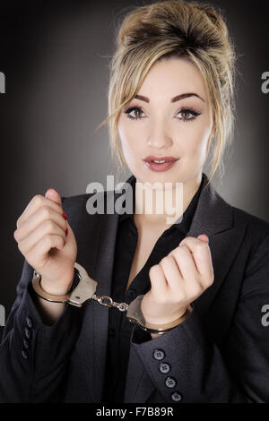 Business donna, ammanettato shot in studio su sfondo grigio Foto Stock