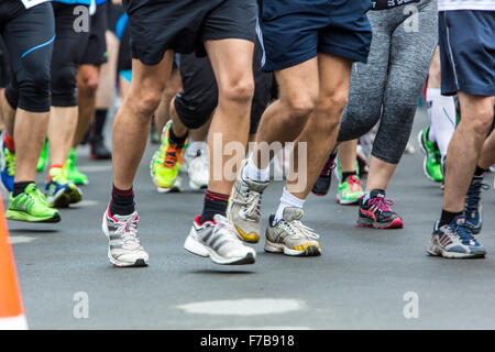 Le gambe dei corridori durante una lunga corsa a distanza Foto Stock