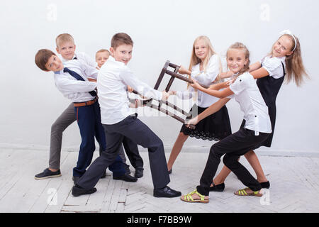 Ragazzi che giocano a tirare di sedia - ragazze rispetto ai ragazzi, Foto Stock