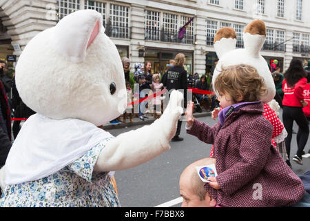 Londra, Regno Unito. Il 28 novembre 2015. Firenze, 2 anni, da Odiham alta cinque un carattere da famiglie di Sylvania. La cerimonia inaugurale di Natale Hamleys Toy Parade avviene lungo Regent Street, che andò e priva di traffico per il giorno. La sfilata organizzata dal famoso negozio di giocattoli Hamleys featured oltre 50 della nazione di figli prediletti di caratteri lungo con 400 animatori, una Marching Band e palloncini giganti. Il corteo è modellata su Macy's annuale di Thanksgiving Parade di New York. Credito: Immagini vibranti/Alamy Live News Foto Stock