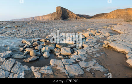 Le splendide formazioni rocciose a bassa marea a Nash punto, Vale of Glamorgan, Galles. Il tramonto è l'illuminazione delle scogliere Foto Stock