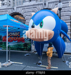 Londra, Regno Unito. Il 28 novembre 2015. Un gonfiabile "Sonic the Hedgehog' carattere cattura l'occhio di un giovane ragazzo come centinaia di persone si radunano in Regent Street, che è stata chiusa al traffico, per godere di personaggi giocattolo, giocattolo e le attività correlate. Hamley, il più antico negozio di giocattoli nel mondo, ospitati, ciò che era stato pubblicizzato come il più grande parata giocattolo mai visto in Gran Bretagna. Credito: Stephen Chung / Alamy Live News Foto Stock