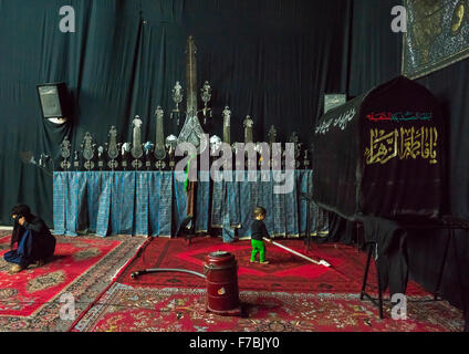 Little Boy giocando con un aspiratore di fronte a un'Alam su Ashura, il giorno della morte di imam Hussein, Provincia di Isfahan, Kashan, Iran Foto Stock