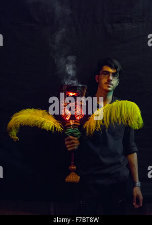 Sciita iraniano uomo musulmano di trattenimento di un bruciatore di incenso durante Ashura, il giorno della morte di imam Hussein, Provincia di Isfahan, Kashan, Iran Foto Stock