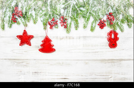 Sfondo di natale. Albero di Abete rami con decorazione rossa e la caduta di neve Foto Stock