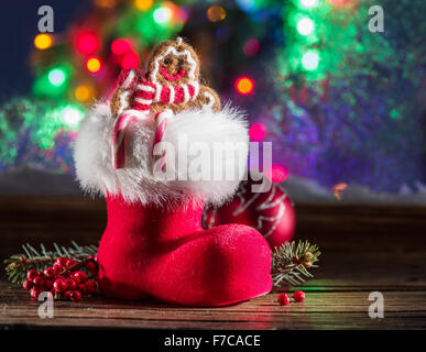 Natale boot rosso al lume di candela di fronte alla finestra congelata. Foto Stock