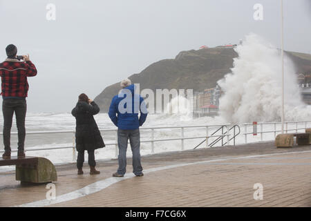 Aberystwyth, Wales, Regno Unito. 29 novembre 2015 Tre pedoni guardare e scattare foto come i grandi onde pastella Aberystwyth questa mattina come tempesta Clodagh combina con marea alta. Credito: Ian Jones/Alamy Live News Foto Stock