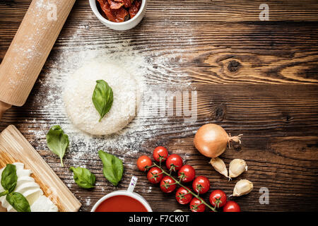 Pizza Pasta con gli ingredienti su legno Foto Stock