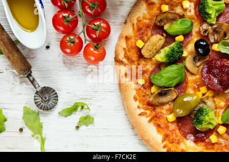 Una deliziosa pizza italiana servita su un tavolo di legno Foto Stock