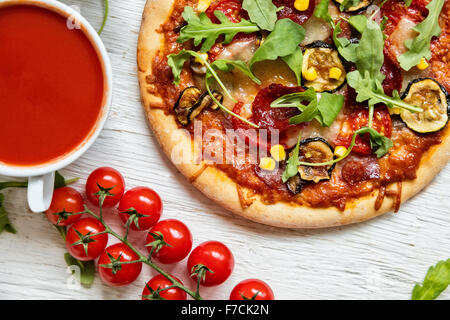 Una deliziosa pizza italiana servita su un tavolo di legno Foto Stock