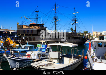 "Black Pearl' party boat in Ayia Napa porto con barche di pescatori locali. Ayia Napa Harbour, Cipro. Foto Stock