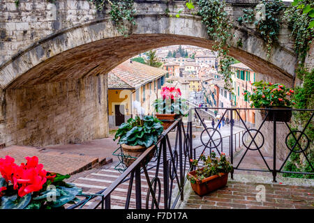 Via dell'Acquedotto di perugia umbria italia, le fasi che conducono giù dall'acquedotto medievale, fiori di colore rosso in bicchieri su parapetti Foto Stock