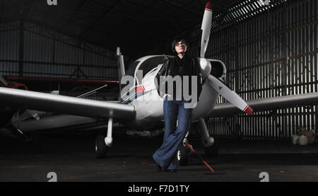 Bella giovane donna modello in moda in posa di fronte del vecchio aereo privato Foto Stock