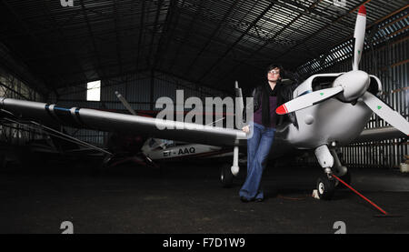 Bella giovane donna modello in moda in posa di fronte del vecchio aereo privato Foto Stock