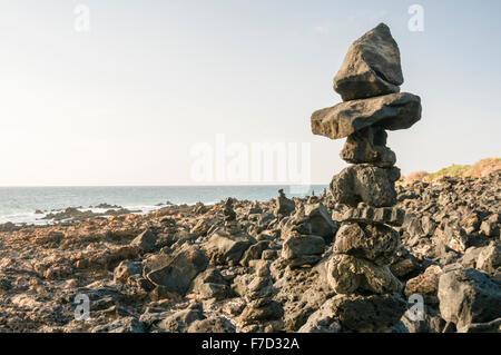 Rocce impilate su di un roccioso Spagnolo Spiaggia Foto Stock