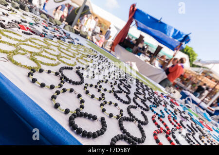 Gioielli fatti a mano in pietra olivina olivina (silicato di ferro di magnesio) per la vendita presso uno stand in un mercato domenicale Foto Stock