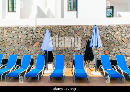 Sedie a sdraio blu su una zona piastrellata in un albergo spagnolo. Foto Stock