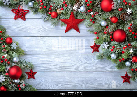 Natale sfondo blu con bordo in legno e rami di abete decorato con rosso e argento e baubles stelle - moderno, un semplice Foto Stock