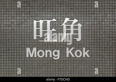 Segno di Mong Kok MTR (metropolitana/metro) stazione di Hong Kong, Cina, scritto in lingua cinese e inglese su grigio tile parete. Vista frontale. Foto Stock