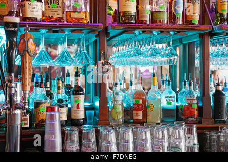 Alcol e bottiglie di liquore allineate in un bar e pub Foto Stock