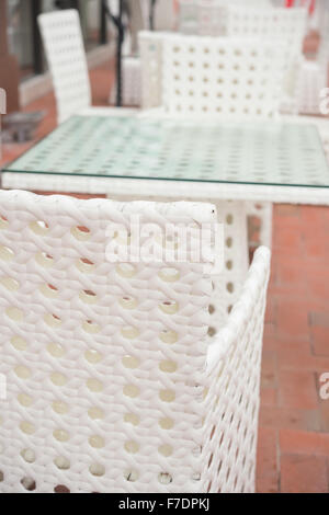 White rattan divano e tabella imposta all'aperto in composizione verticale Foto Stock