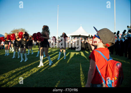 Un giovane ragazzo guardando la UNLV (Università di Las Vegas) ribelli Cheerleaders al un calcio ribelli pre-evento di gioco Foto Stock