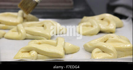 La pasticceria sagomate sono ammessi a lievitare prima della cottura, la vetratura è stato applicato fotografati con un panificio boutique Foto Stock