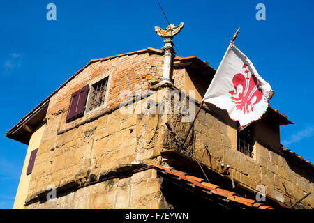 Dettaglio di un edificio e una bandiera con lo stemma della città (giglio) in Pnte vecchio - Firenze, Italia Foto Stock