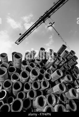 La gru e la pila di tubi Foto Stock