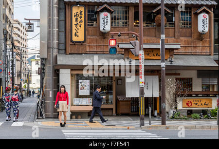 Ragazza giapponese in attesa di cross Road nella città di Kyoto in Giappone Foto Stock