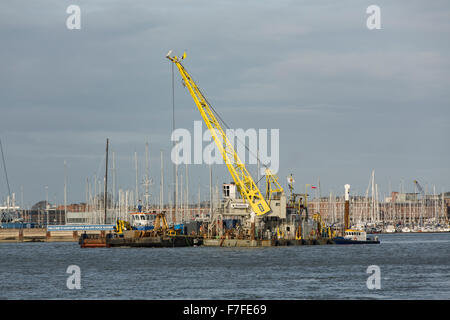 Gru su un pontone galleggiante nel porto di Portsmouth. Esecuzione di lavori di dragaggio in preparazione del nuovo RN vettori aerei Foto Stock