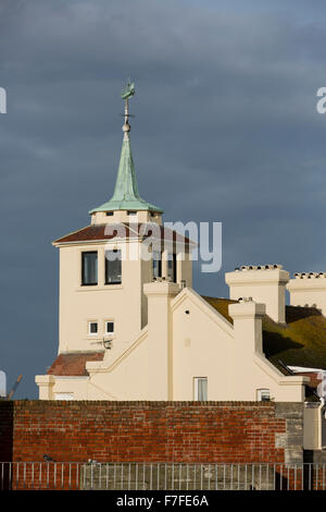 Casa torre con un vecchio banderuola nella forma di un galeone. Dettaglio set shot contro un cielo grigio. Foto Stock