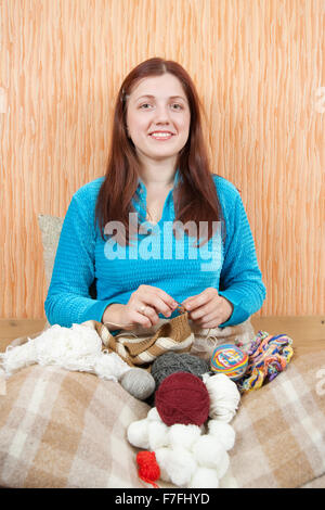 Giovane donna una tessitura a maglia-pin a casa Foto Stock