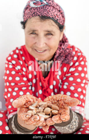 Donna che mantiene i dadi di argan in Marocco. Foto Stock