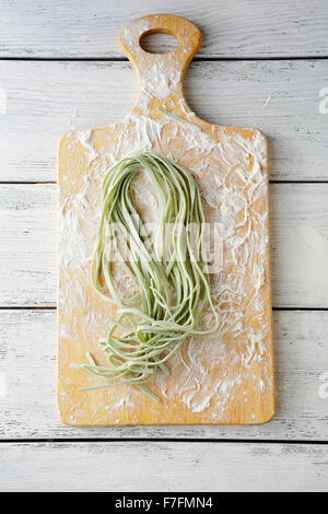 Materie spinaci pasta sul tagliere, vista dall'alto Foto Stock