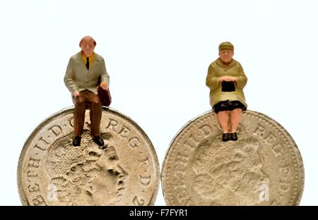Miniatura gente seduta su una libbra di monete Foto Stock