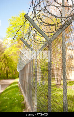 Filo spinato sulla recinzione metallica, maglia di catena recinzioni in nessuna area sconfinamenti, di sicurezza e di controllo di accesso di recinzione di garza costruzione... Foto Stock