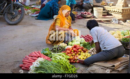 Scena di strada con india donna indù in sari verdure di vendita sul mercato, Jaisalmer, India Foto Stock