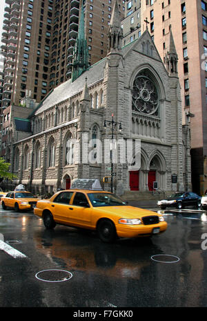 New York taxi gialli in movimento da una strada di città in scena con una chiesa e skycrapers in basso Foto Stock