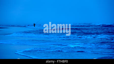 Pescatore solitario, pesca da surf sulla spiaggia, tarda serata, K'gari Foto Stock