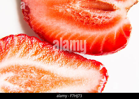 Un open fragola fotografato close-up su sfondo bianco concettualizzare la freschezza, la dolcezza o la molla Foto Stock