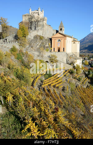 Castello e Chiesa di Saint-Pierre sopra un vigneto con colori autunnali al loro picco. Valle d'Aosta, Italia. Foto Stock