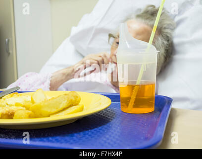 Cibo da ospedale. Paziente anziano nel suo degli anni novanta mangiare in ospedale NHS in Inghilterra, Regno Unito Foto Stock